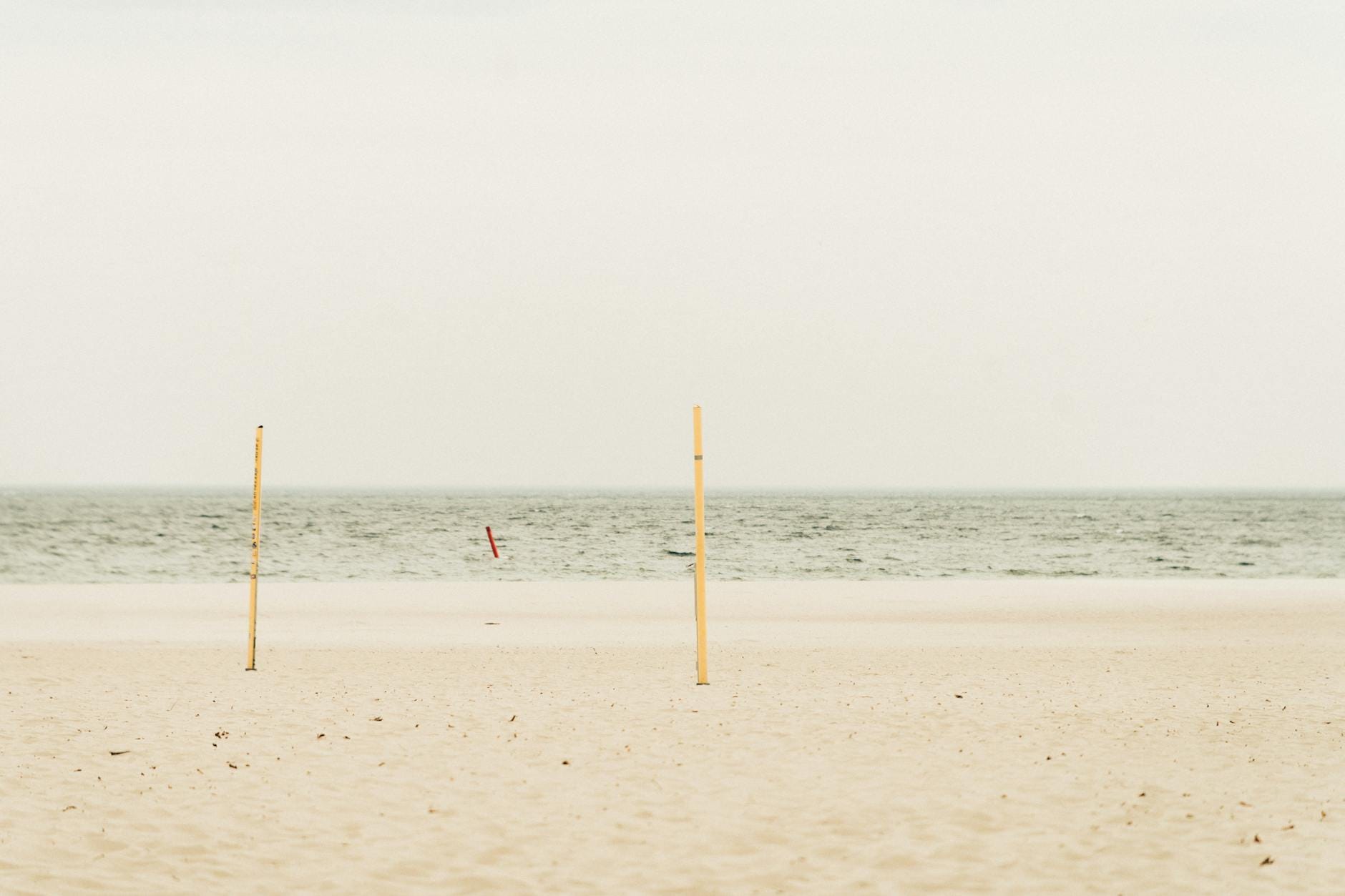 Pusta, szeroka plaża nad Bałtykiem pod pochmurnym niebem