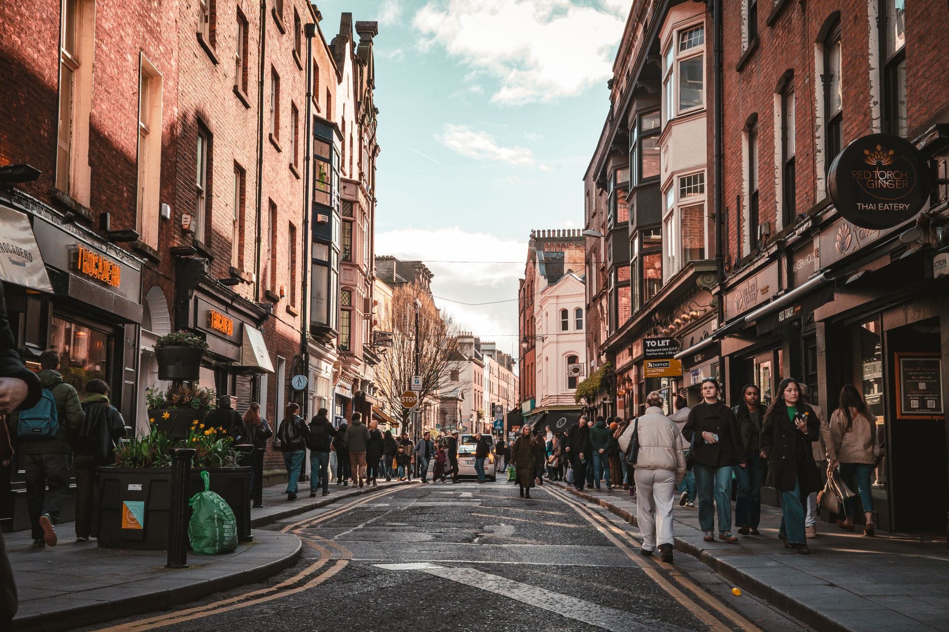Ruchliwa ulica Temple Bar w Dublinie z pieszymi i historycznymi kamienicami