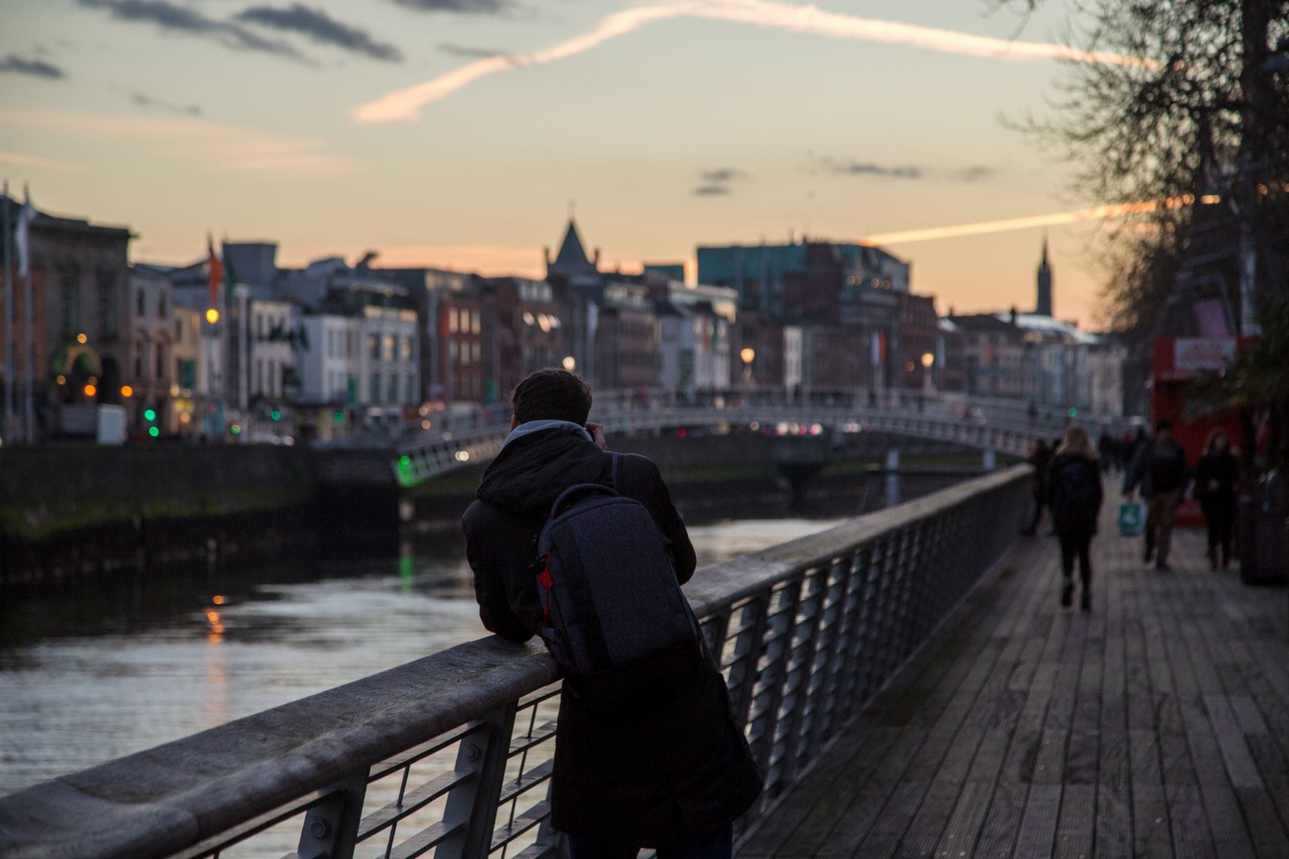 Sylwetka przechodnia o zachodzie słońca na moście Ha'penny w Dublinie