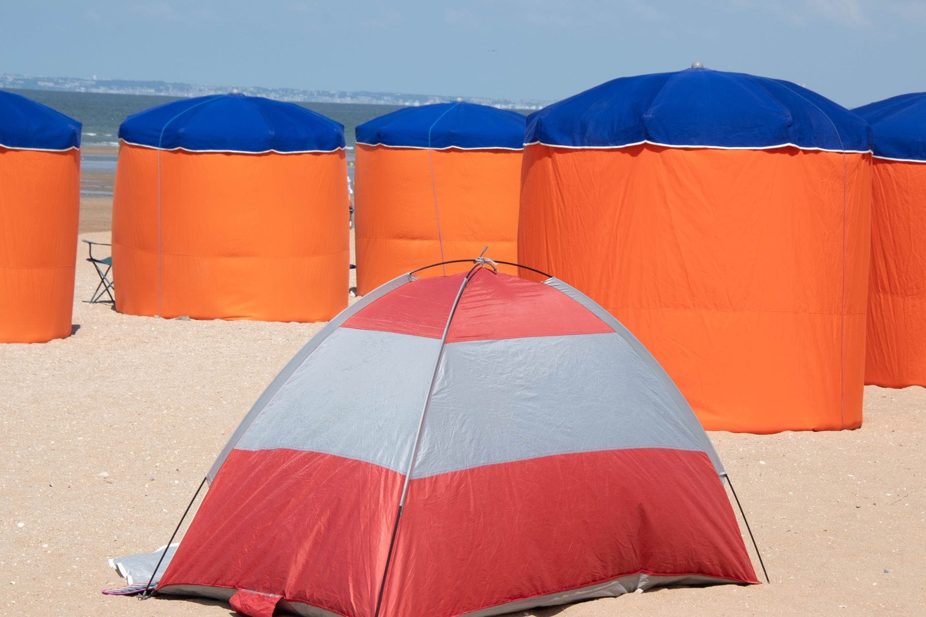 Kolorowe namioty plażowe na słonecznej plaży w Normandii